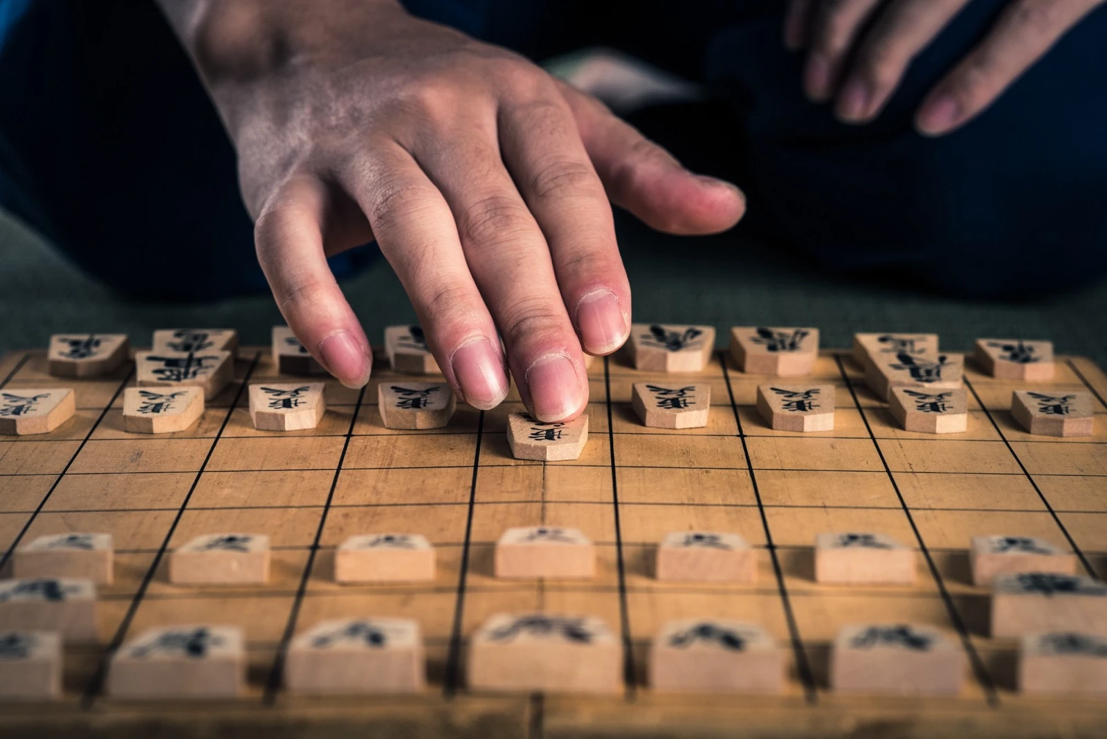 将棋盤の上で、指先で歩を一つ前へ進める手